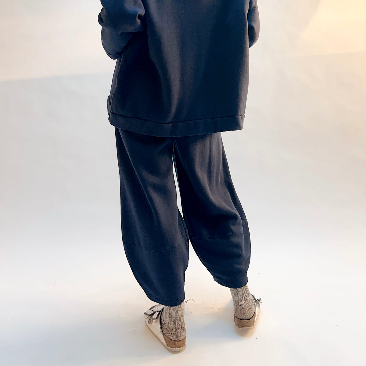 Back view of Oliver Fleece Pant in Nova on a model, showing the rounded legs and tapered hems.