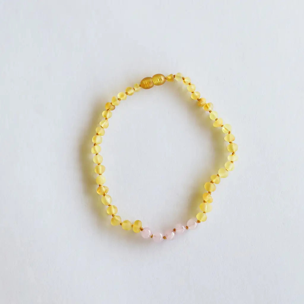 CanyonLeaf raw honey Baltic amber and rose quartz beaded necklace with hand-knotted cord and screw clasp, laid flat on a white background