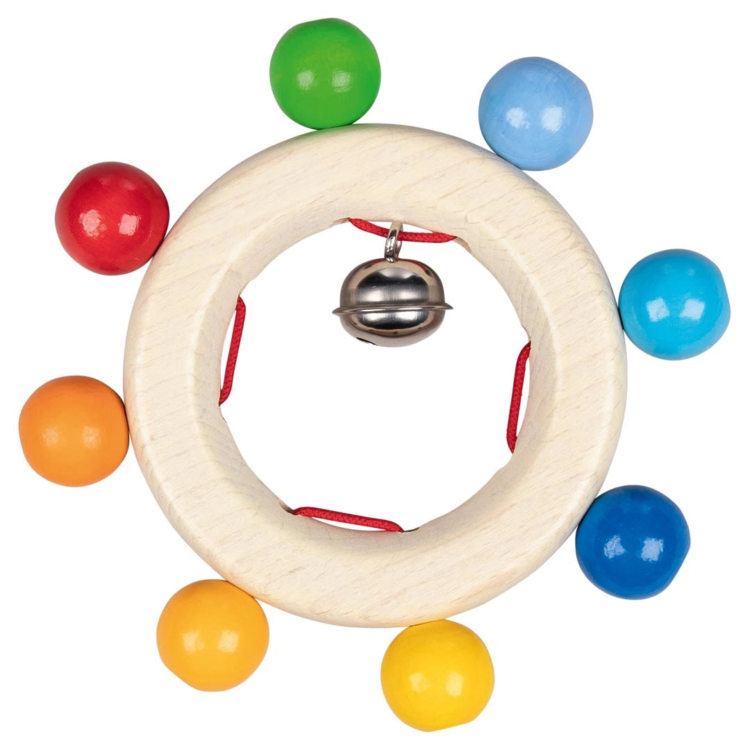 Goki Rainbow Bead Wooden Grasp Rattle on a white background, showing a smooth natural wood ring with 8 round rainbow-colored wooden beads threaded on red cord around the outside in red, orange, yellow, green, light blue, teal, and dark blue, with a small silver jingle bell hanging at the center