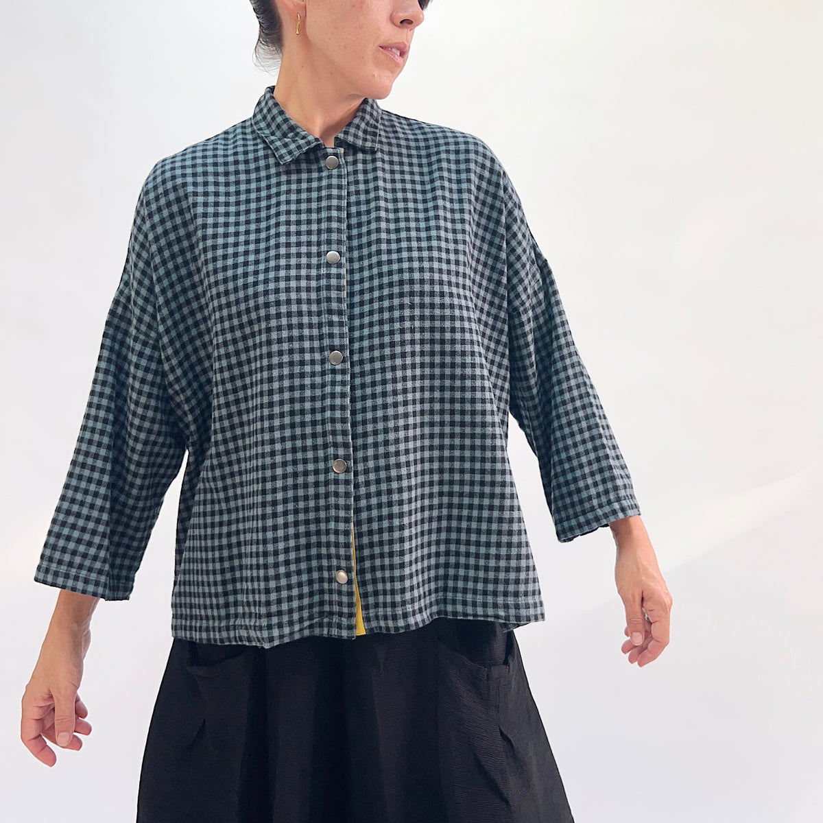 Eleven Stitch Small Check Big Shirt in Dusty Denim, full front view showing the boxy hip-length fit, point collar, and mustard contrast placket in dusty teal and black small gingham check flannel