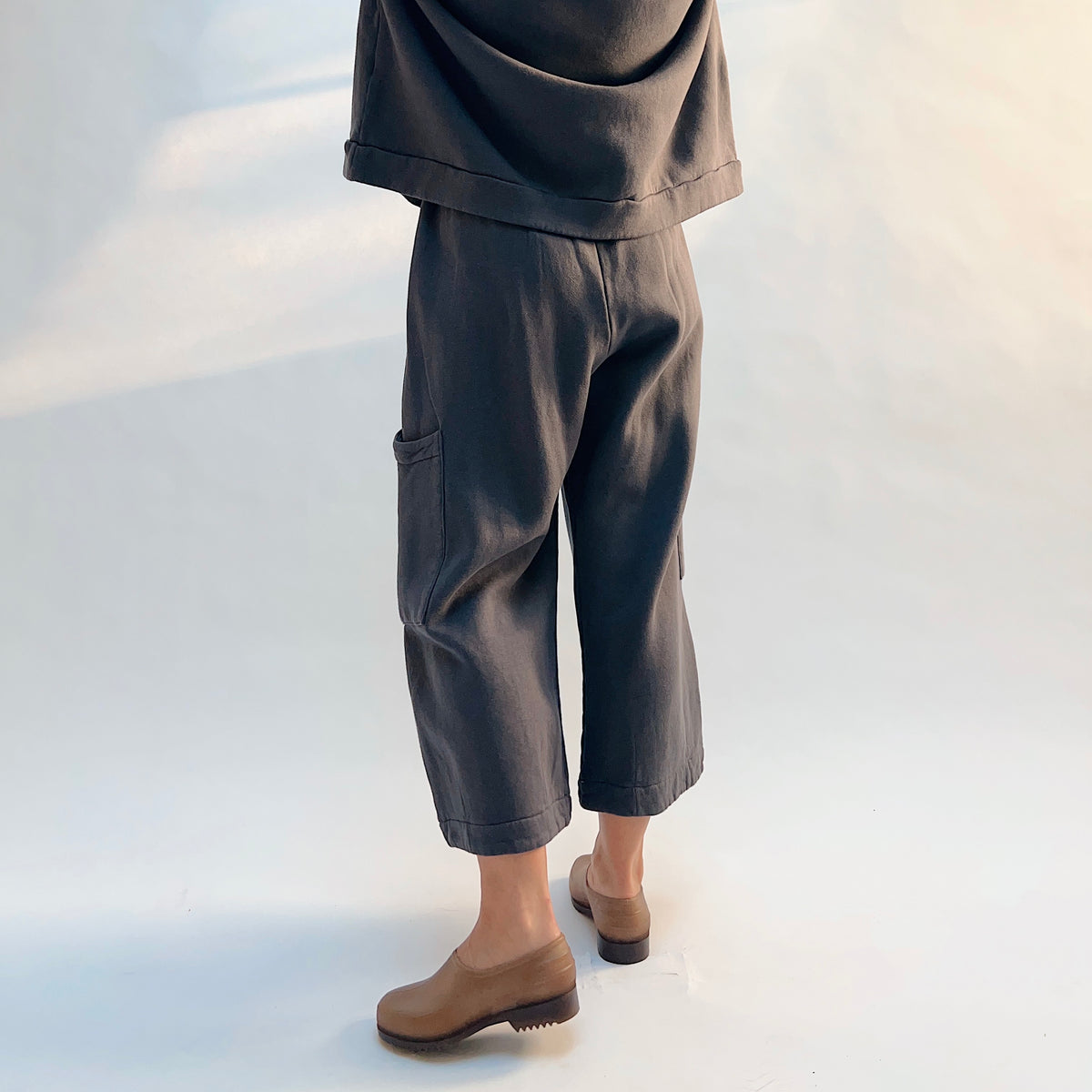 Angled back view of Pasha Fleece Pant in Moonlight, showing the cropped legs and side patch pocket.