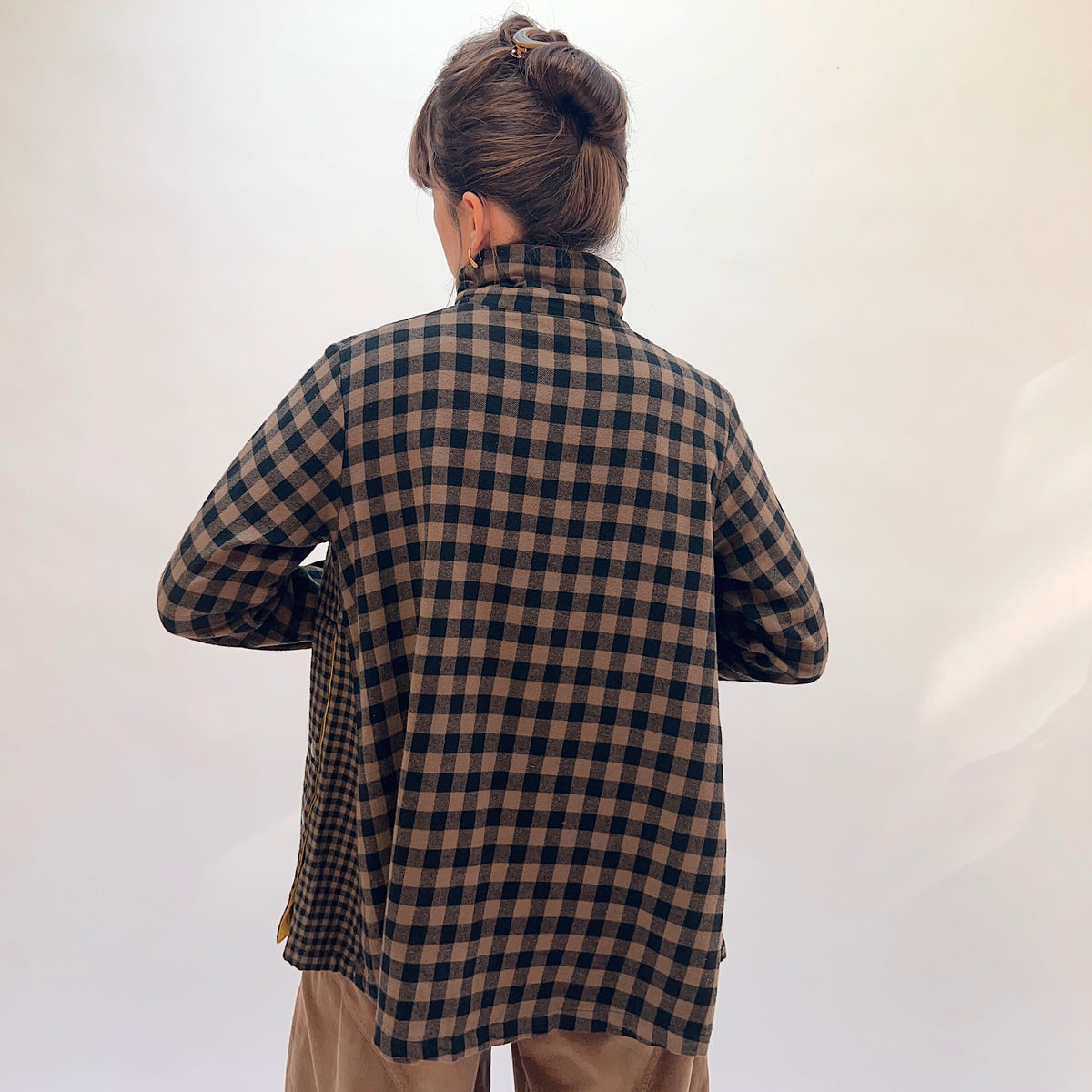 Eleven Stitch Placket Gusset Shirt in Winter Olive, back view showing the relaxed oversized fit, high funnel collar, and side gusset snap vents in brown and black gingham check cotton