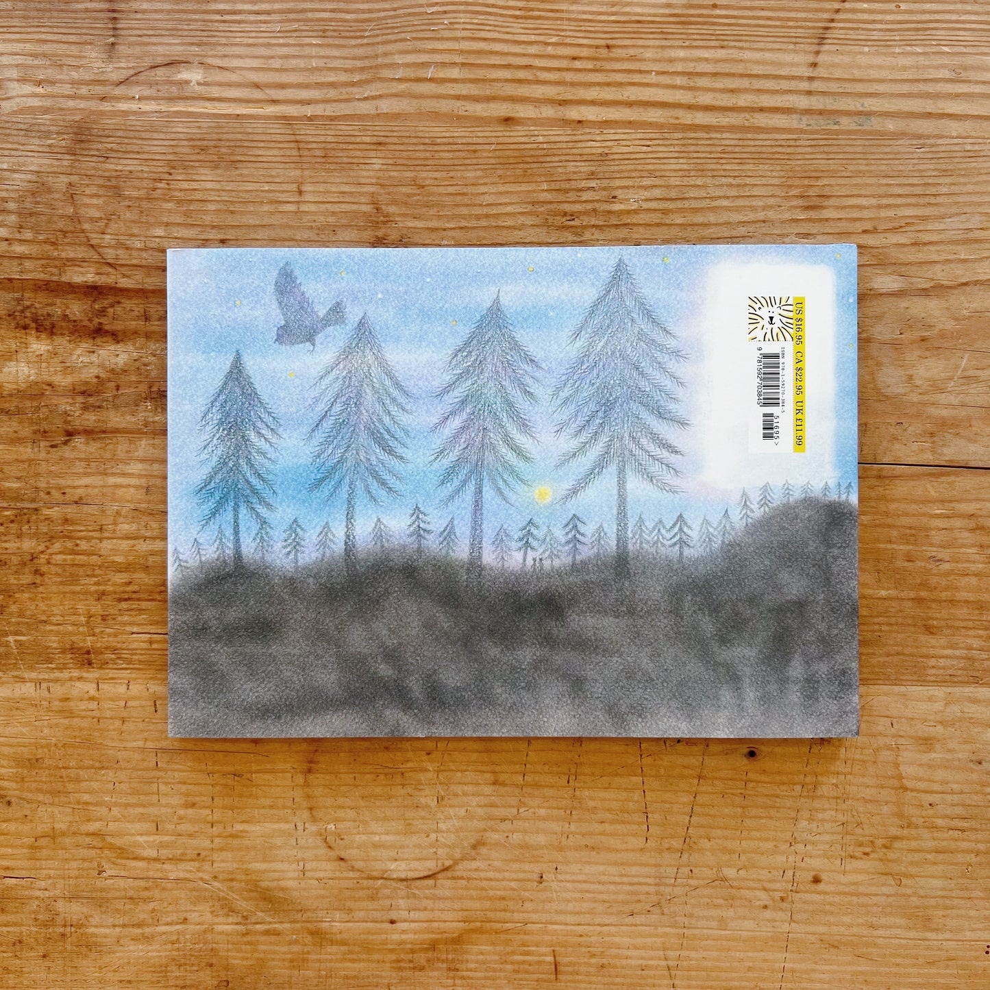 The back cover of the book showing an illustration of a forest, the moon and a bird