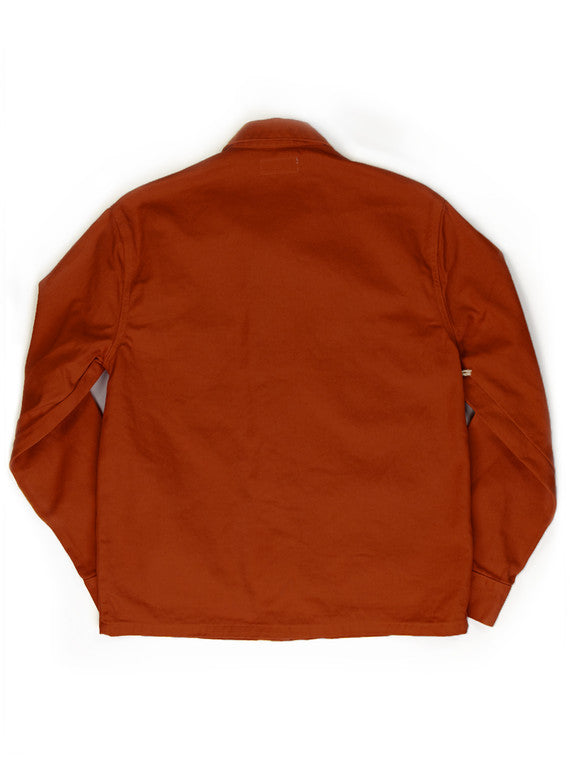 Back view of the Tellason Garment Dyed Coverall Jacket in International Orange, showing the clean back panel, long sleeves, and Tellason label at the collar