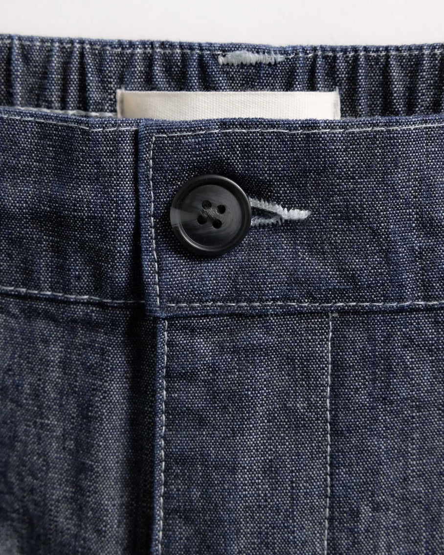 Close-up of a button on a denim fabric pocket with a white background