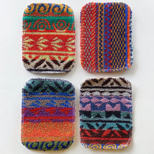Load image into Gallery viewer, Four scrubby pad sponges lying side by side as seen from above. They are colorful and made up of unique patterns.