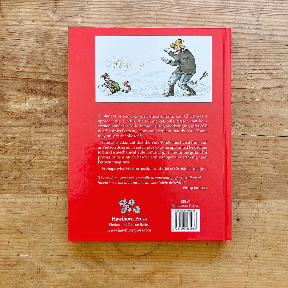 Red back cover of Findus and the Christmas Tomte, showing Pettson and Findus playing in the snow above the story summary.
