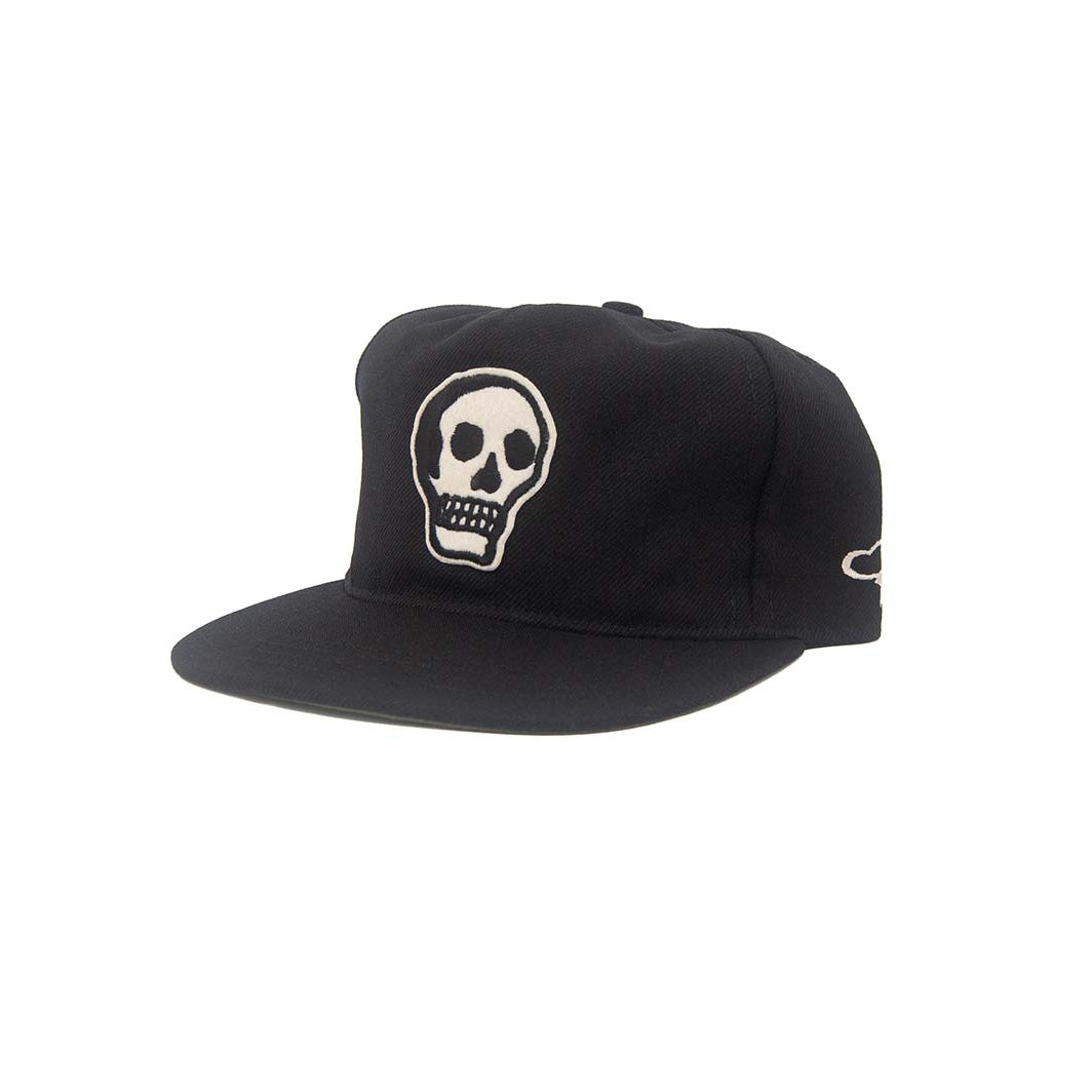 Three-quarter side view of the Ampal Creative Skull II Black Snapback, showing the embroidered white skull on the front panel, Ampal script logo on the side panel, and flat brim snapback silhouette in black poly, on a white background
