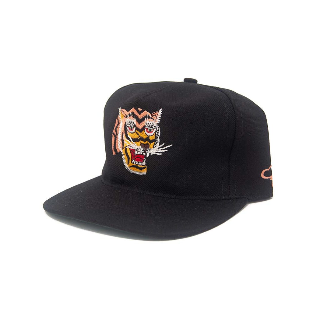 Three-quarter side view of the Ampal Creative Tiger III Black Snapback, showing the embroidered roaring tiger head on the front panel, Ampal script logo embroidered on the side panel, and flat brim snapback silhouette in black poly, on a white background
