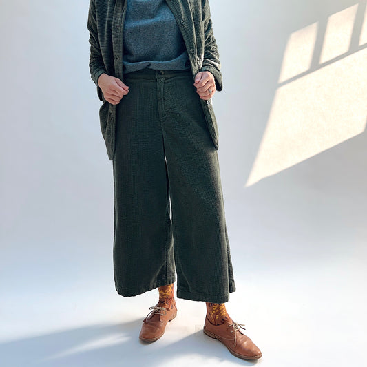 Model wearing the Cut Loose Lux Corduroy Crop Wide Leg Pant in Kelp with a matching blazer, showing the wide legs and cropped hems.
