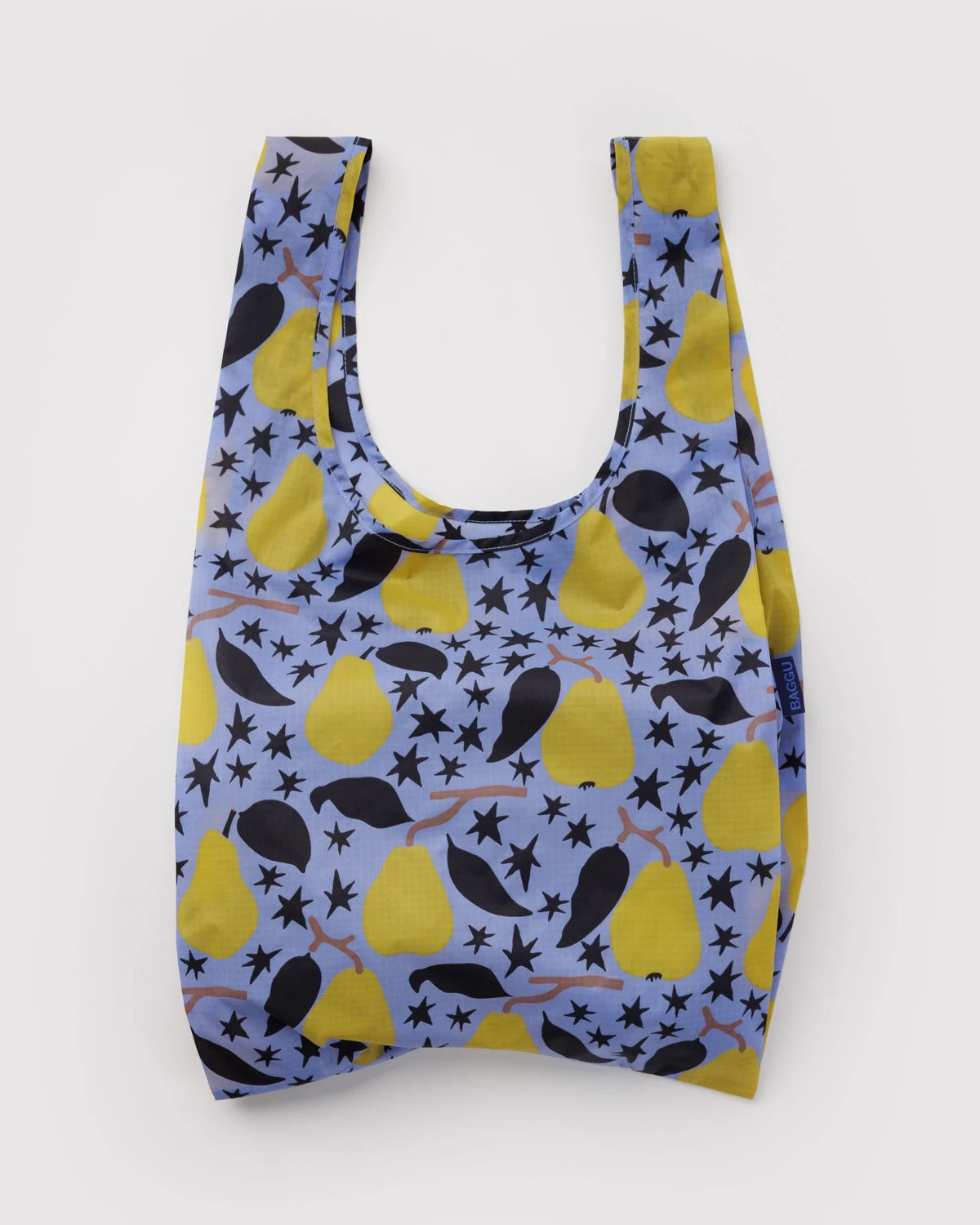 BAGGU Standard Baggu in Golden Pears, shown unfolded with two handles and yellow pears, black leaves, and stars on light blue fabric.
