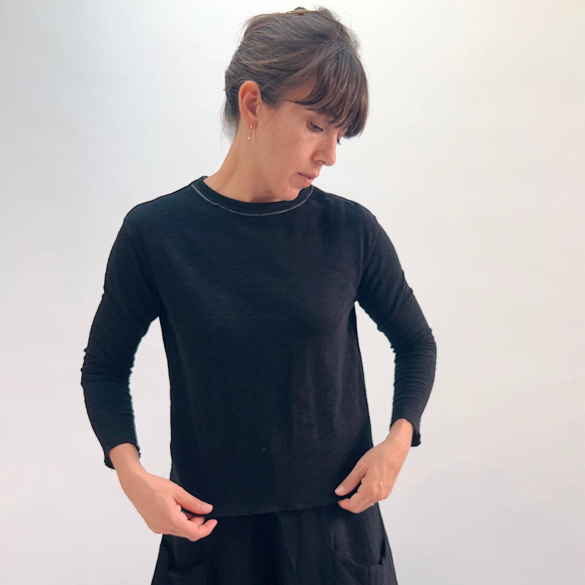 North Star Base Double Cotton Tee in Black, front view showing the slightly cropped double-layered long-sleeve fit with raw-edge neckline and curved hem
