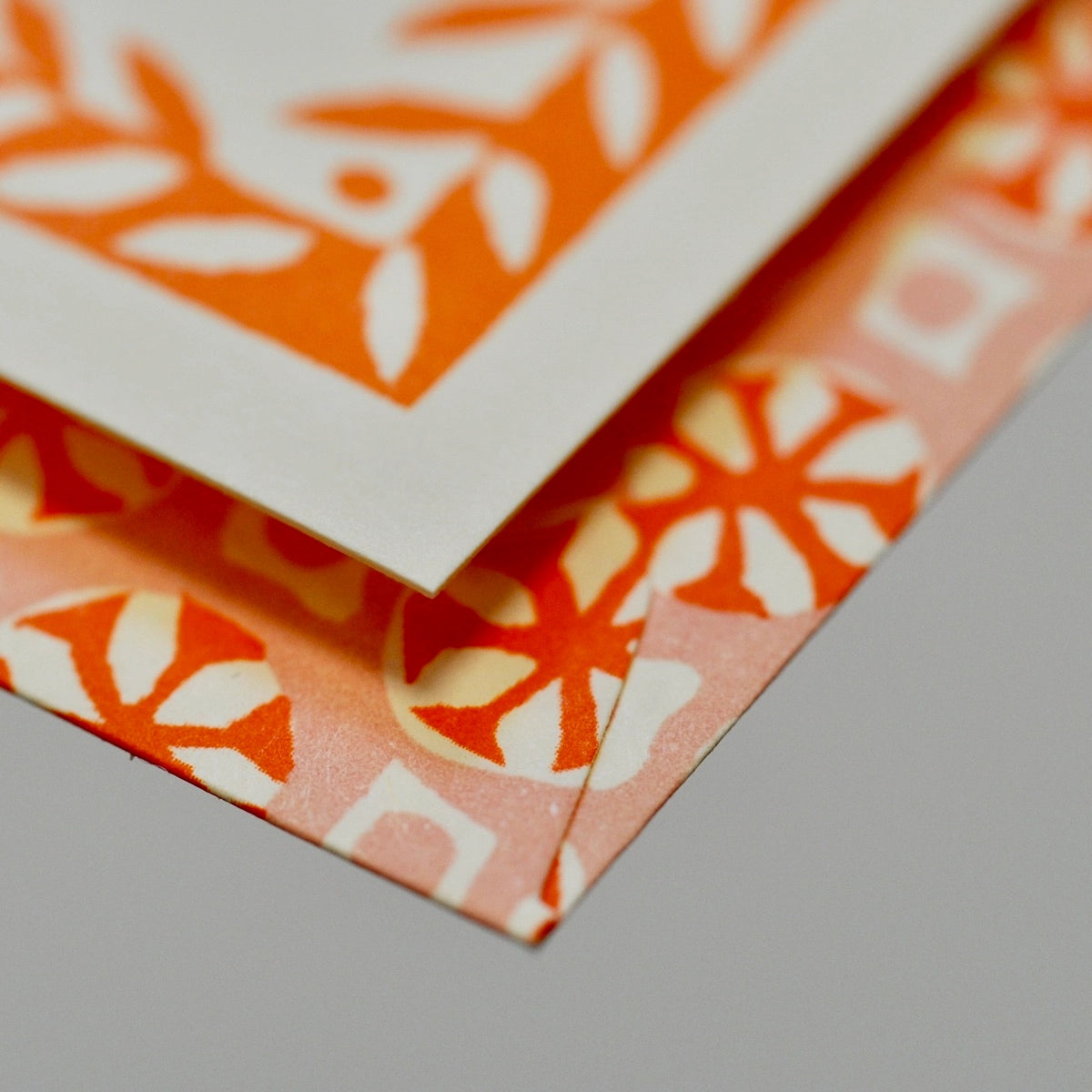 Stack of orange and white patterned paper on a gray surface