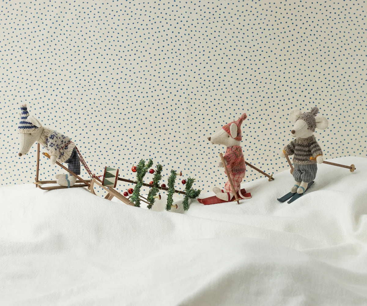 Maileg Winter Mouse Ski Dad — lifestyle scene of three Maileg mouse dolls in winter ski outfits on a snowy white surface, with a miniature sled, Christmas tree, and holiday accessories

