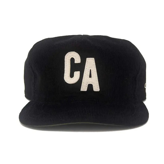 Front view of the Ampal Creative CA Snapback in black 14-wale corduroy, featuring a cream vintage felt CA appliqué on the front panel and an unstructured crushable crown with flat brim, on a white background
