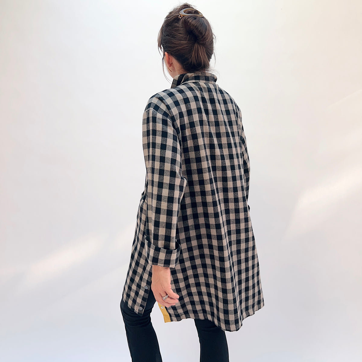 Eleven Stitch Duster in Fennel, back view showing the relaxed knee-length silhouette and mustard contrast side vents in black and natural gingham check cotton flannel
