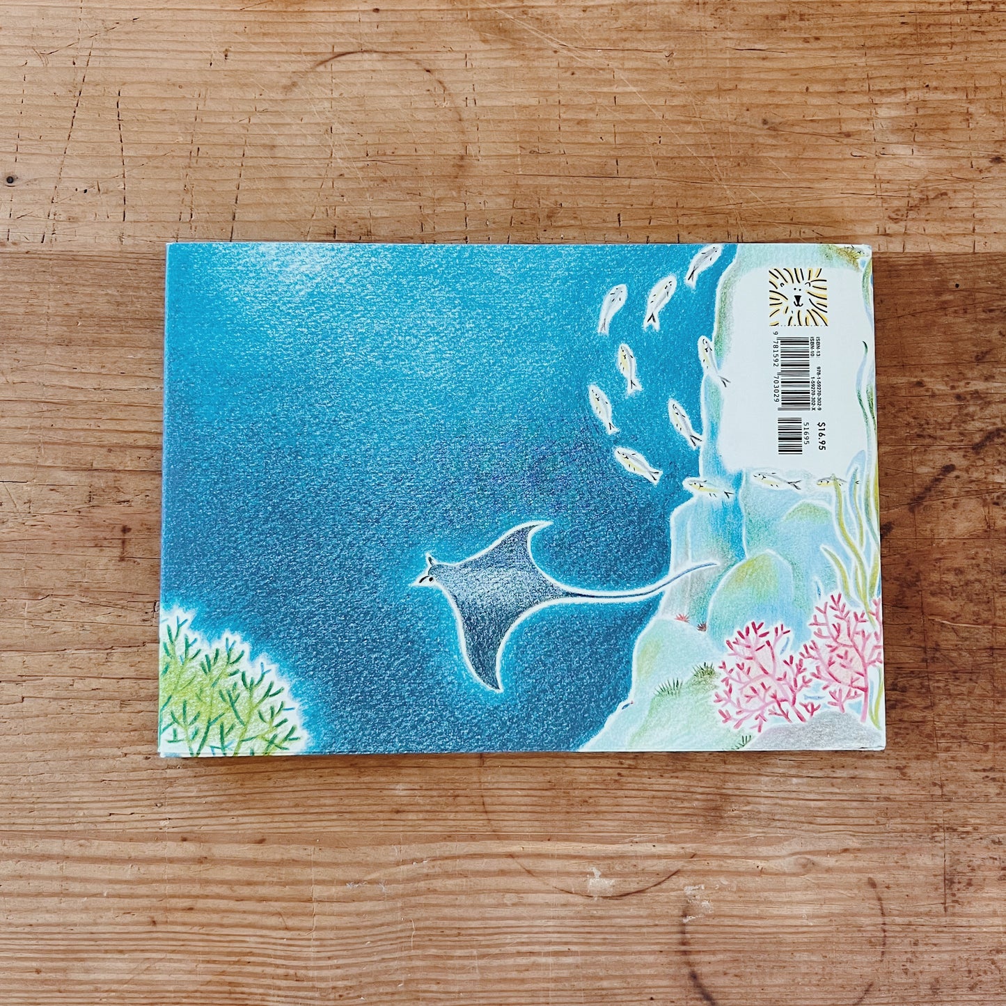 The back cover of the book showing an illustration of the ocean with fish and coral