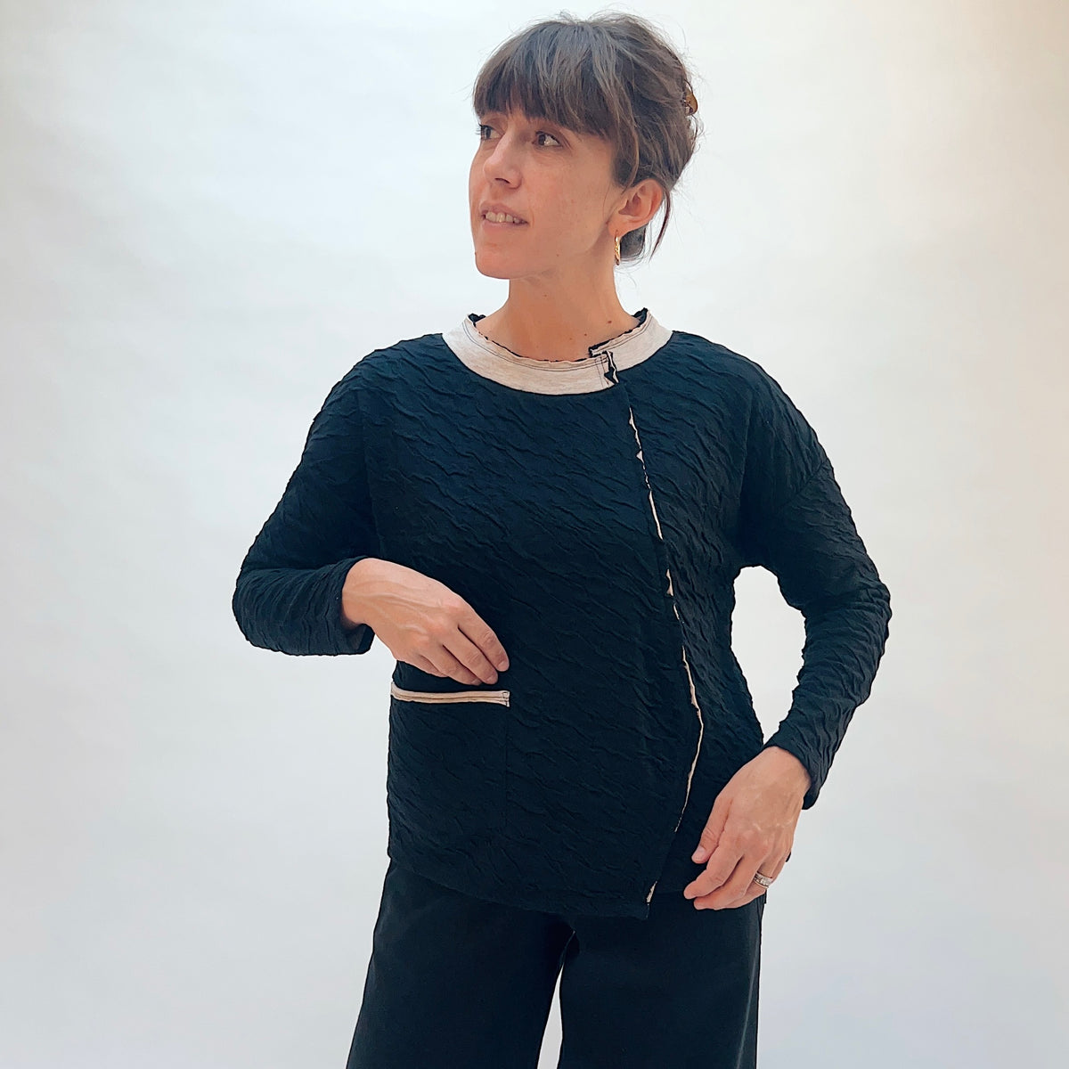 Habitat Crinkled Double Face Metro Pullover in Black, front three-quarter view showing the crinkled texture and contrast crew collar with lettuce edge trim
