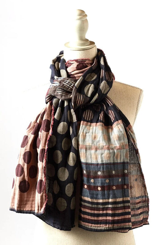 Létol Coline Scarf in Marine Bordeaux, draped and knotted on a linen dress form against a white background, showing a reversible Jacquard-woven organic cotton scarf — one side featuring large taupe and grey polka dots with internal stripe detailing on a deep navy ground, the other showing burgundy polka dots on a blush pink ground with a multicolored stripe border in navy, blush, and taupe — with the fringe edge and pink selvedge visible at the hem
