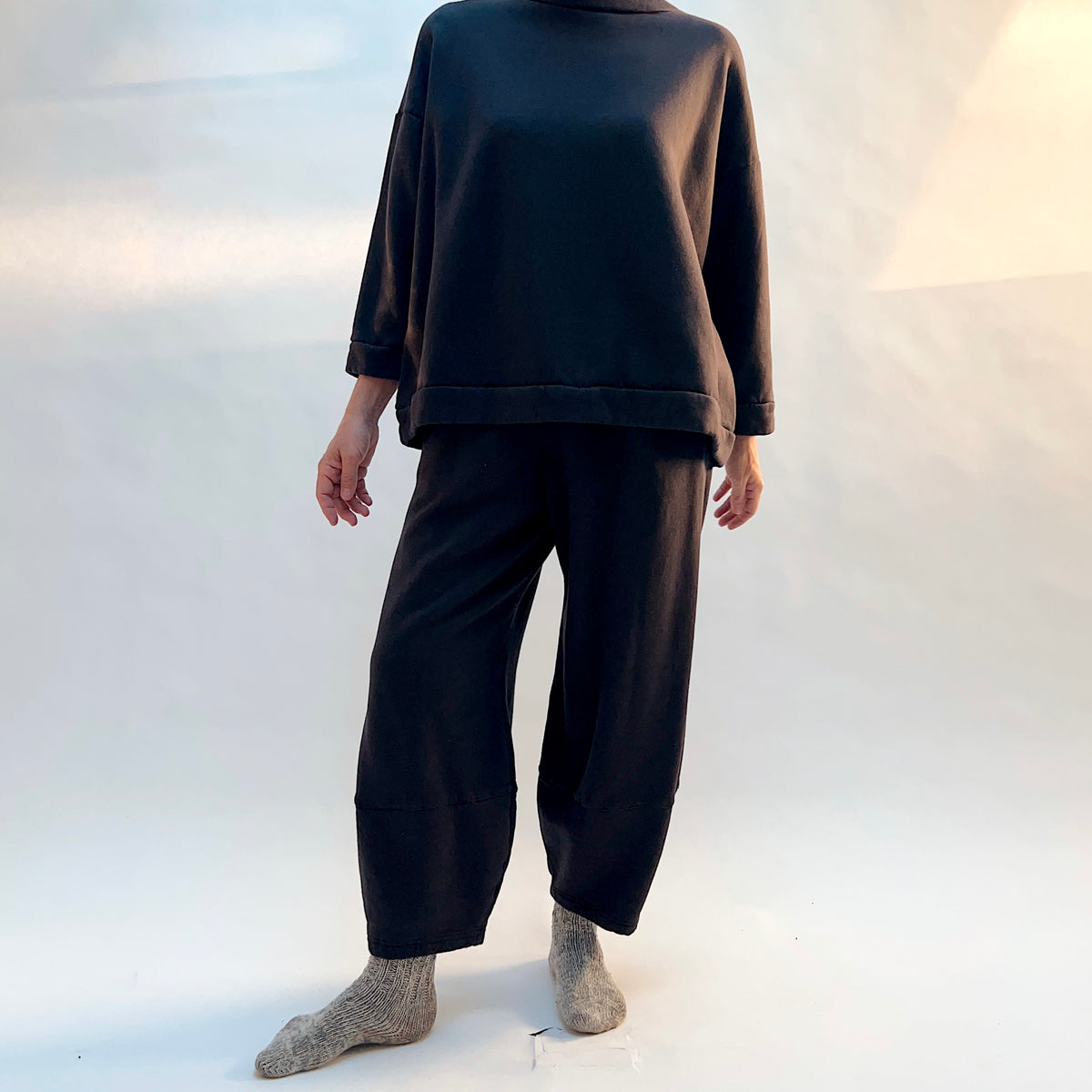 Front view of Bryn Walker Oliver Fleece Pant in Fig on a model, showing the rounded legs tapering toward the ankles.
