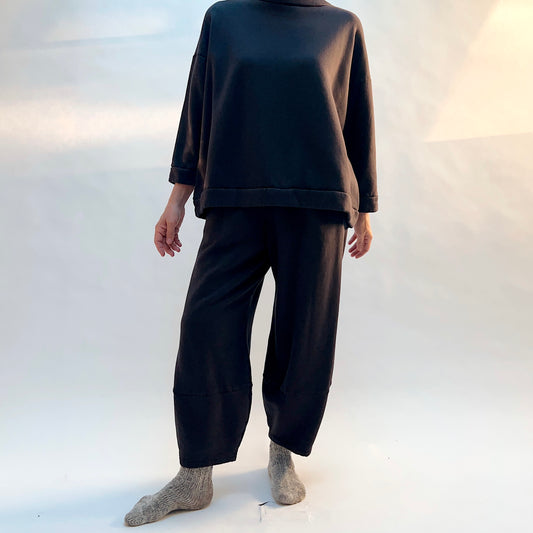 Front view of Bryn Walker Oliver Fleece Pant in Fig on a model, showing the rounded legs tapering toward the ankles.
