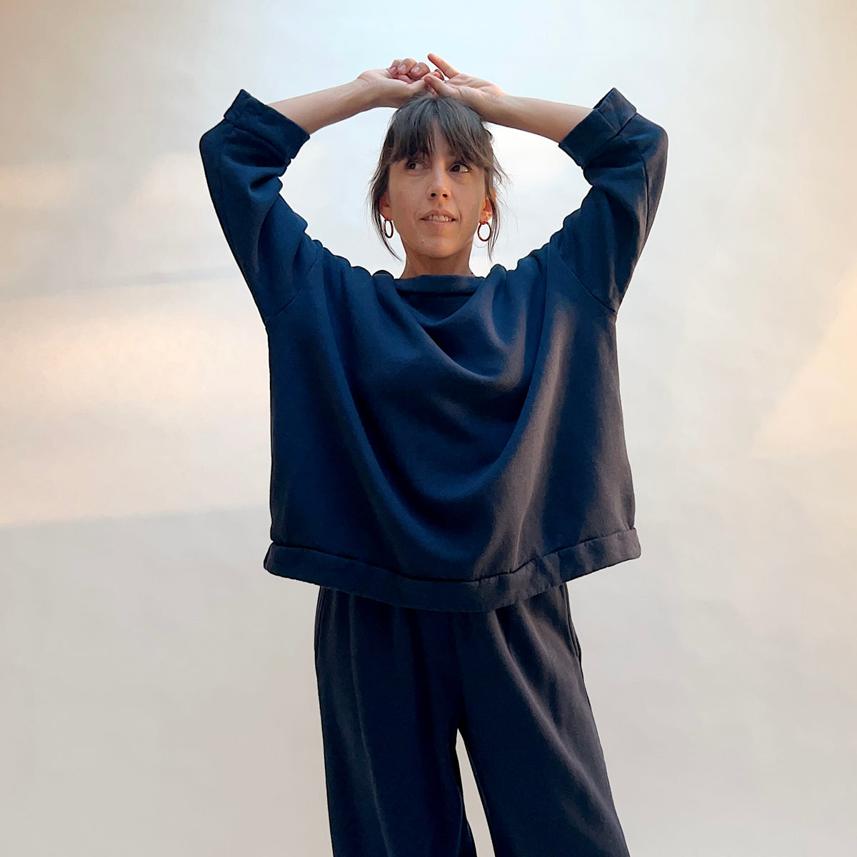 Model wearing Alden Fleece Sweatshirt in Nova with arms raised, showing the oversized shape and wide sleeves.
