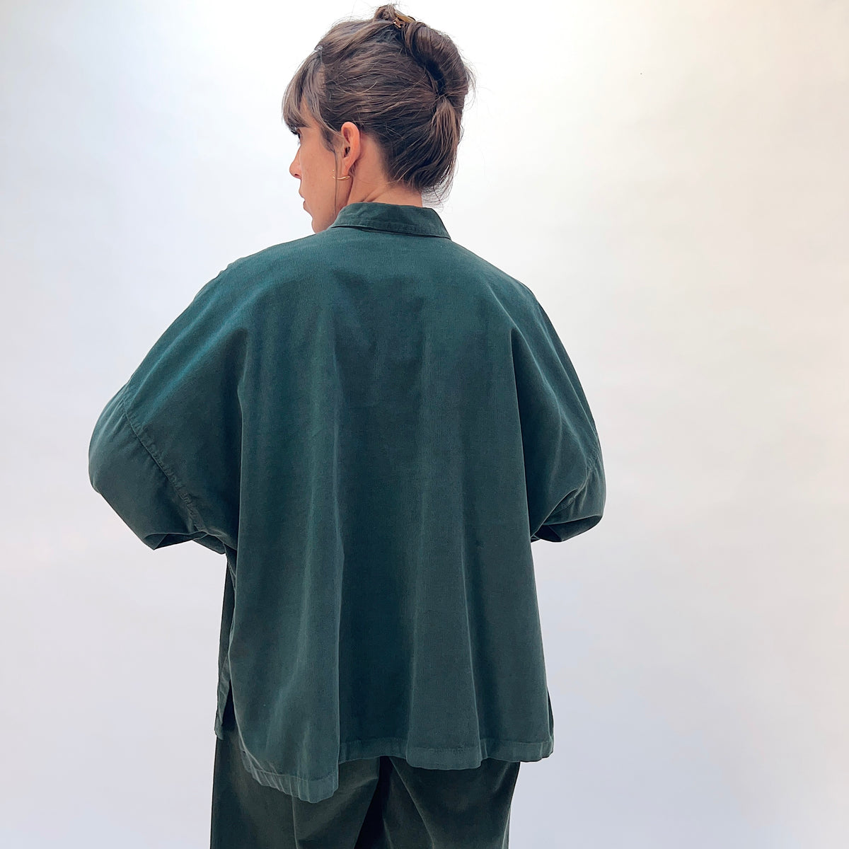 Eleven Stitch Corduroy Big Shirt in Konbu, back view showing the relaxed oversized fit and side slit detail in dark green fine-wale corduroy
