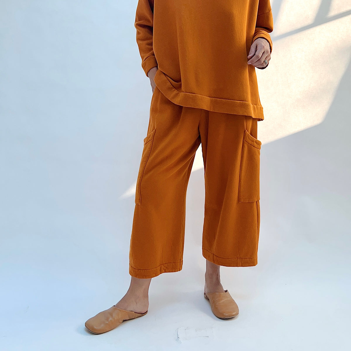 Front view of Bryn Walker Pasha Fleece Pant in Yera on a model, showing cropped wide legs and large thigh patch pockets.
