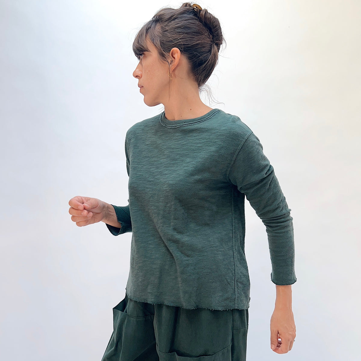 North Star Base Double Cotton Tee in Konbu, side view showing the crew neck with raw-edge finish and slightly cropped sleeves in konbu green
