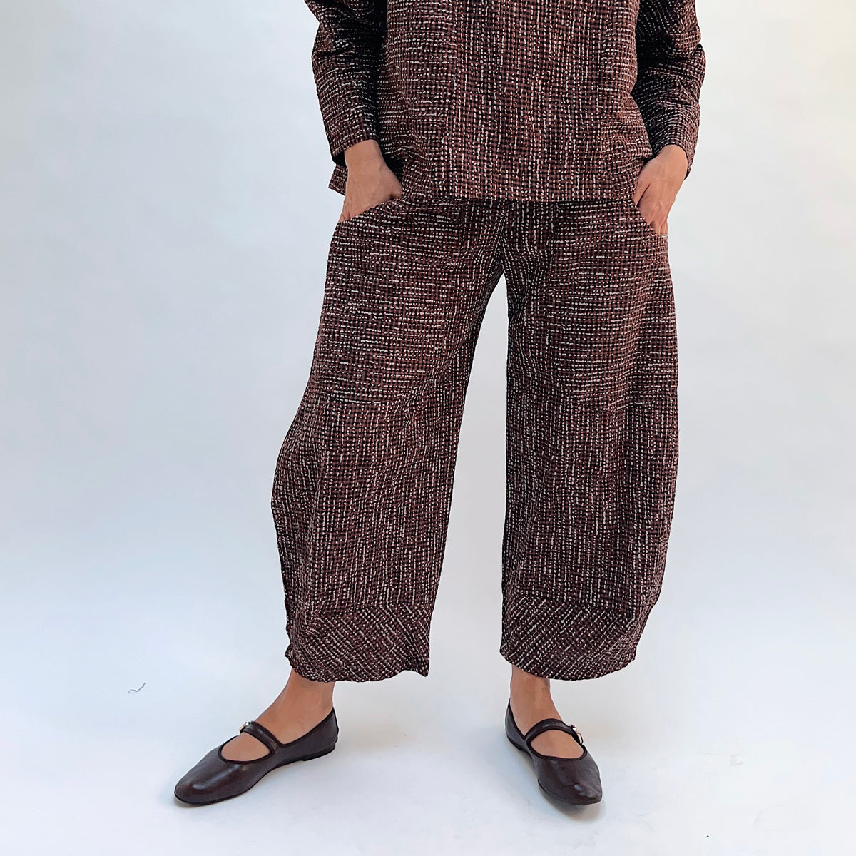 Niche Izzie Pant in Cocoa Check, front view showing the wide-leg silhouette in dark brown textured check print with elastic waistband and front pockets

