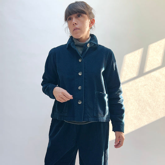 Front view of the Cut Loose Lux Corduroy Cropped Jacket in Etan on a model, showing the raised collar, button front, and patch pockets.
