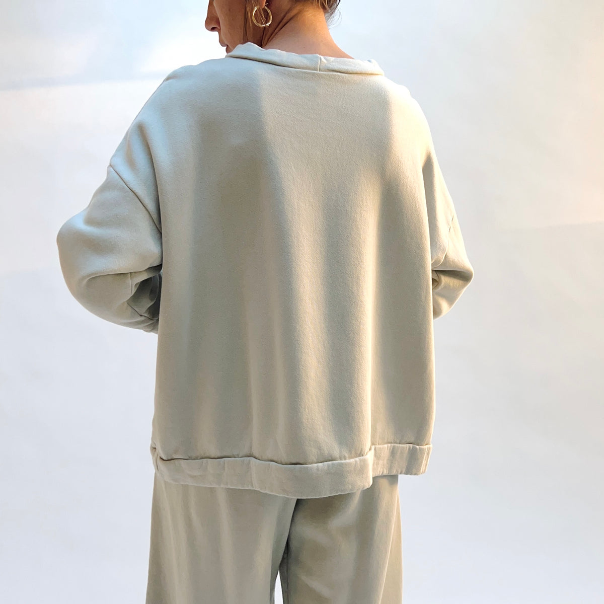 Back view of Alden Fleece Sweatshirt in Orlaya on a model, showing the wide silhouette, dropped shoulders, and banded hem.

