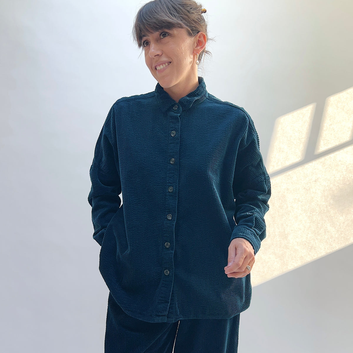 Front view of the Cut Loose Lux Corduroy Oversized Shirt in Etan on a model, showing the collar, button front, and dark teal corduroy.
