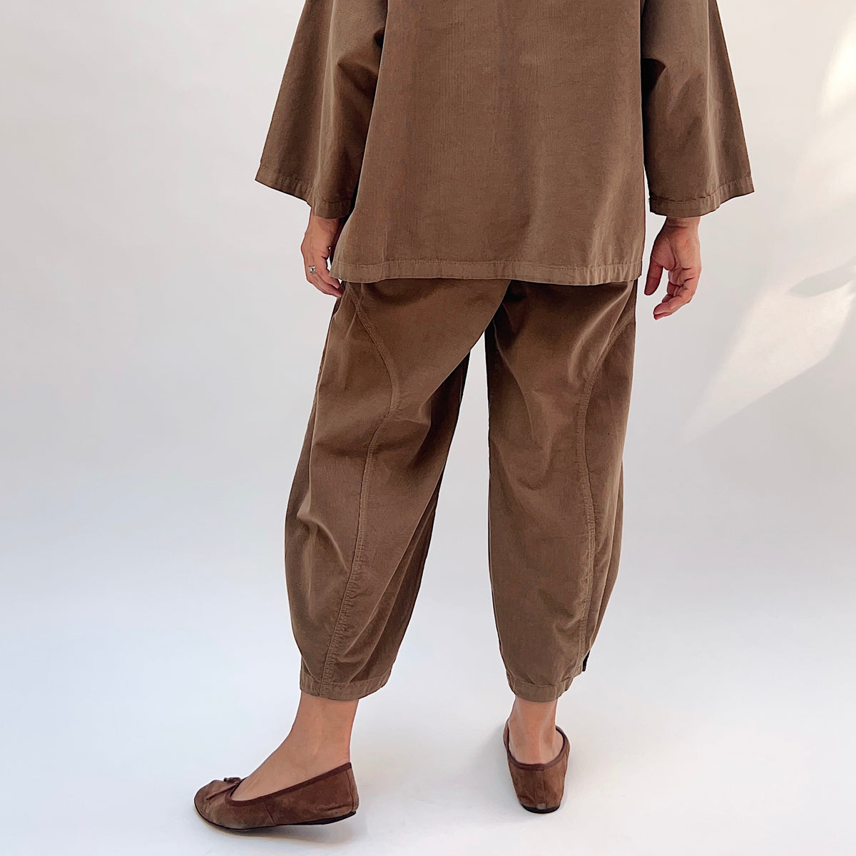 Eleven Stitch Corduroy Doreen Pant in Winter Olive, back view showing the balloon leg silhouette and gathered ankle cuffs, styled with a matching corduroy top
