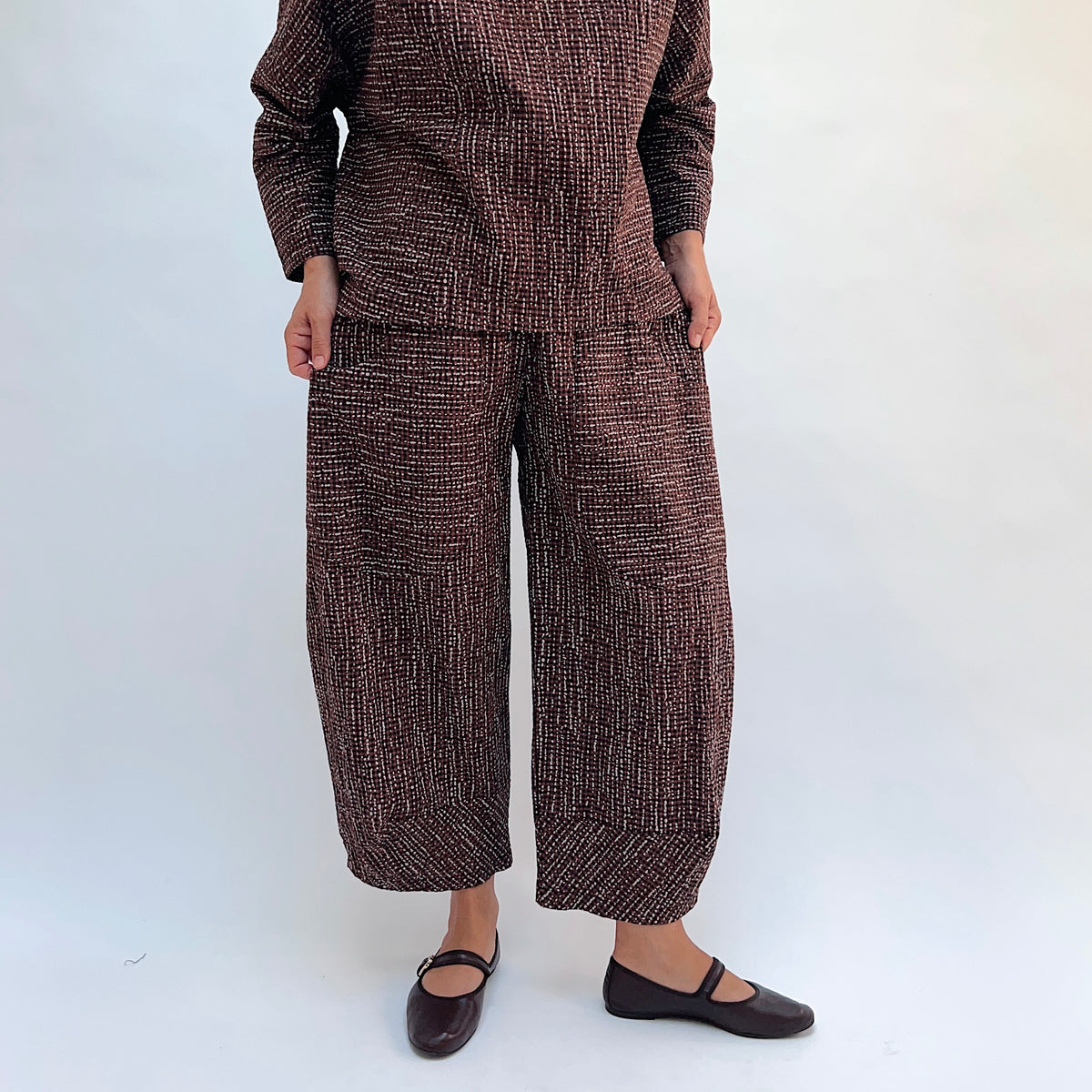 Niche Izzie Pant in Cocoa Check, front view showing the full wide-leg silhouette and elastic waistband in dark brown textured check print
