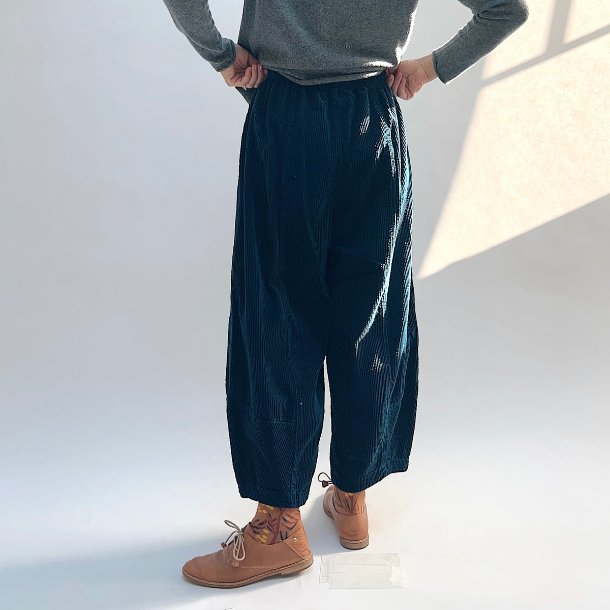 Back view of the Lux Corduroy Lantern Pant in Etan on a model, showing the gathered waistband and shaped legs.
