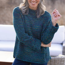 Load image into Gallery viewer, Woman wearing a teal sweater standing outdoors with blurred background
