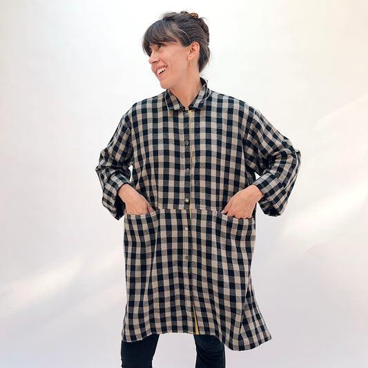 Eleven Stitch Duster in Fennel, front view showing the knee-length oversized silhouette in black and natural gingham check flannel with mustard contrast side snap vent
