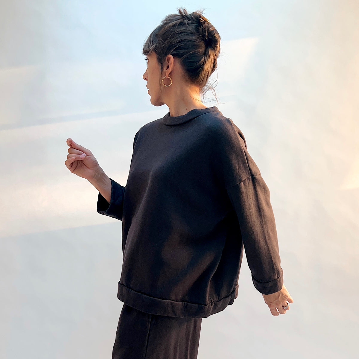 Side view of Alden Fleece Sweatshirt in Fig on a model, showing the loose drape, dropped shoulder seam, and banded hem.
