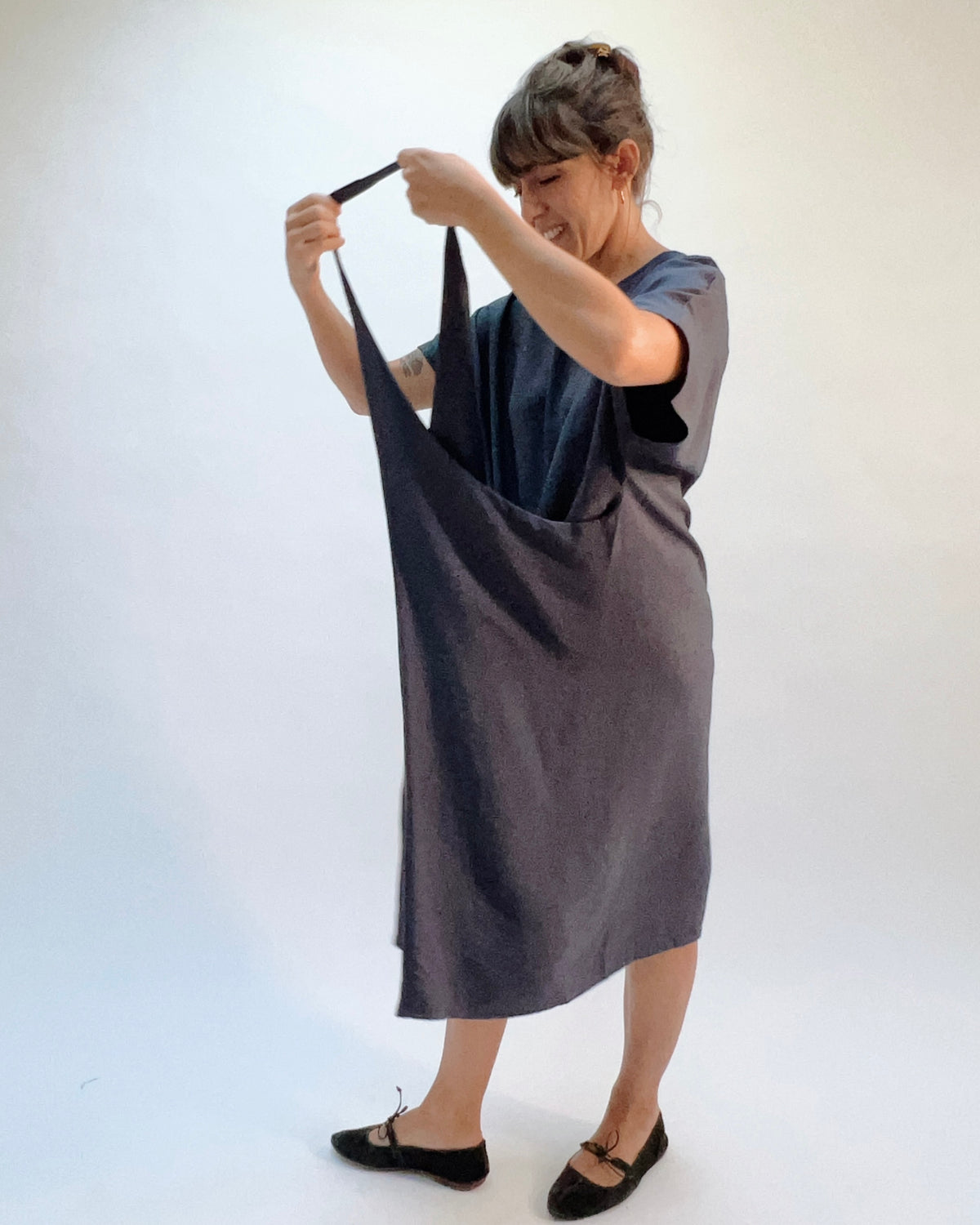 Niche Origami Dress in Carbon, model demonstrating the adjustable strap construction showing the versatile multi-way styling in dark carbon rayon
