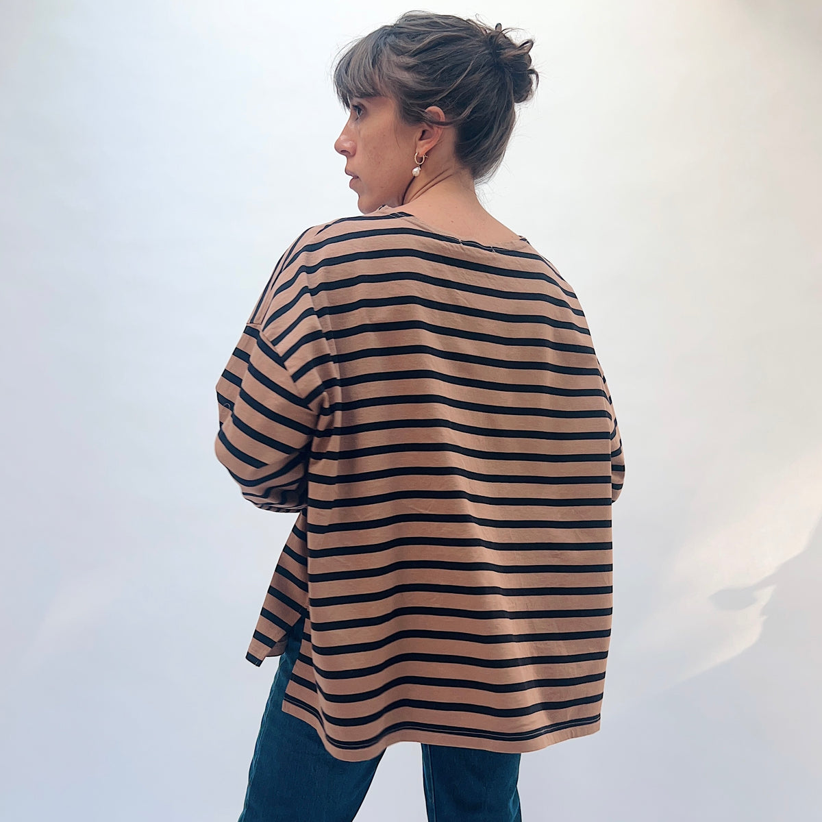 Back view of the mocha and navy striped knit pullover, showing horizontal stripes and dropped shoulders.
