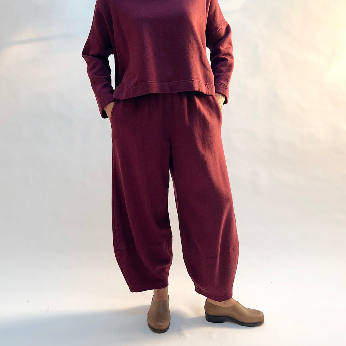 Front view of Oliver Fleece Pant in Rhone with the model’s hands in the side pockets, showing the rounded leg shape.
