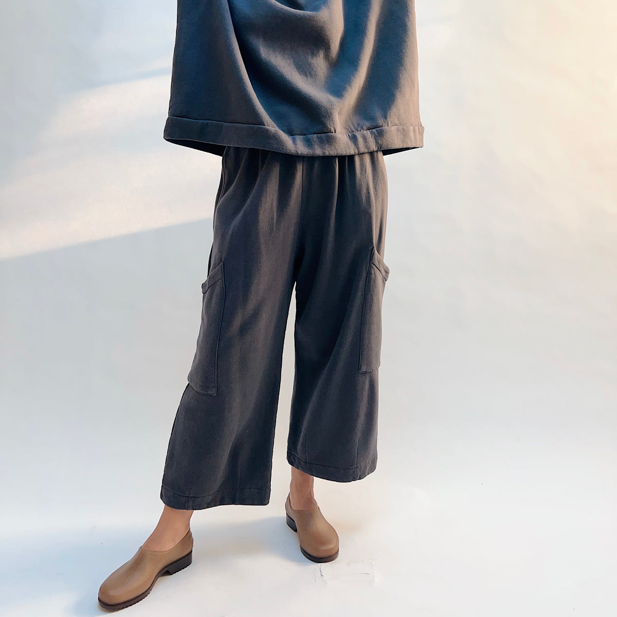Angled front view of Pasha Fleece Pant in Moonlight on a model, showing the loose drape and thigh patch pockets.
