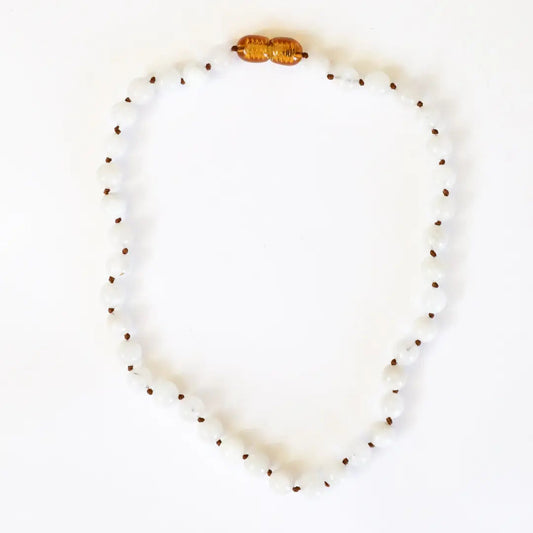 CanyonLeaf Pure Gemstone + Moonstone Necklace — a hand-knotted necklace of smooth translucent white moonstone beads with dark brown knots between each bead and a honey amber screw clasp, laid flat on a white background