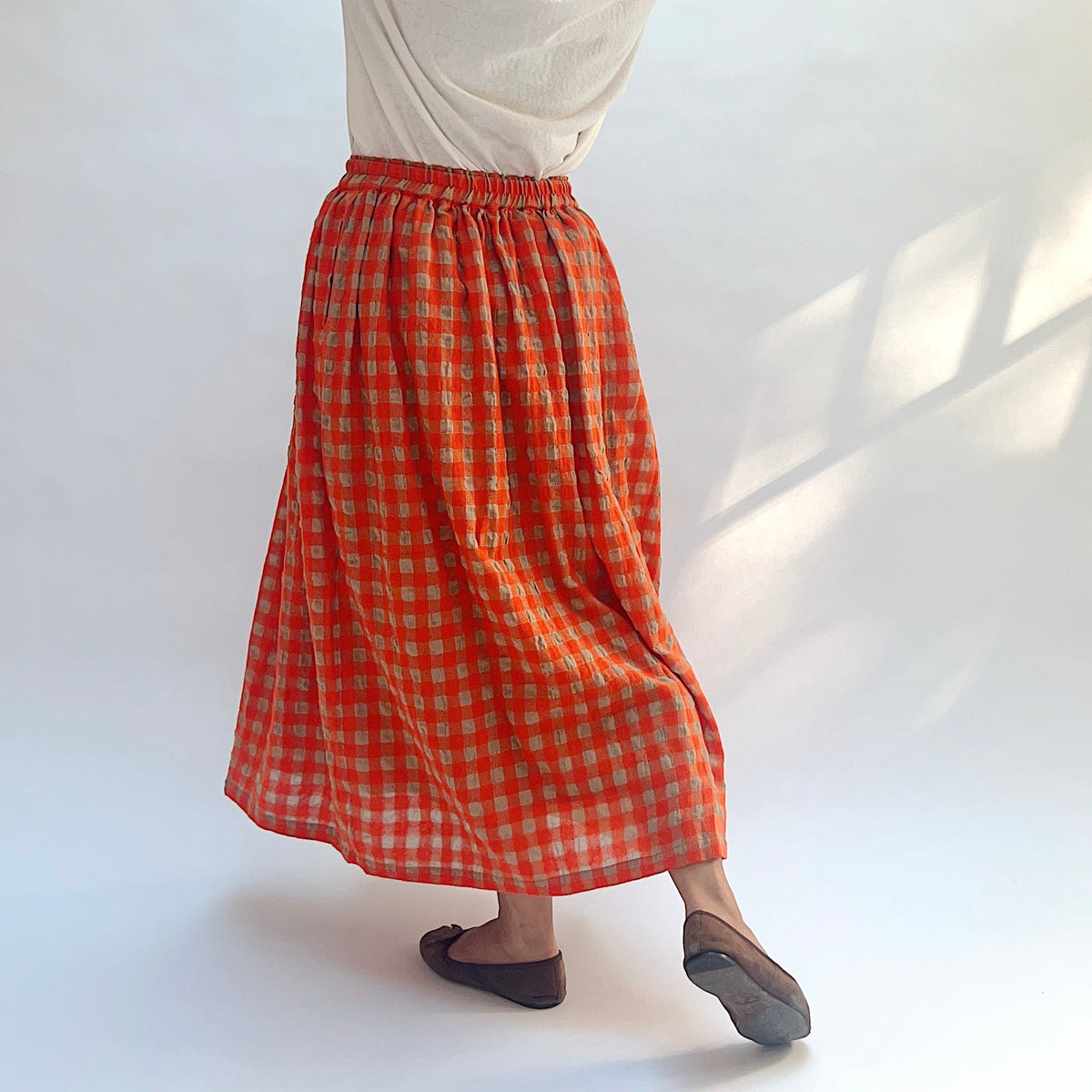 Ichi Antiquités Gingham Wool Check Skirt in Beige & Orange, angled back view showing the gathered waist and drape.
