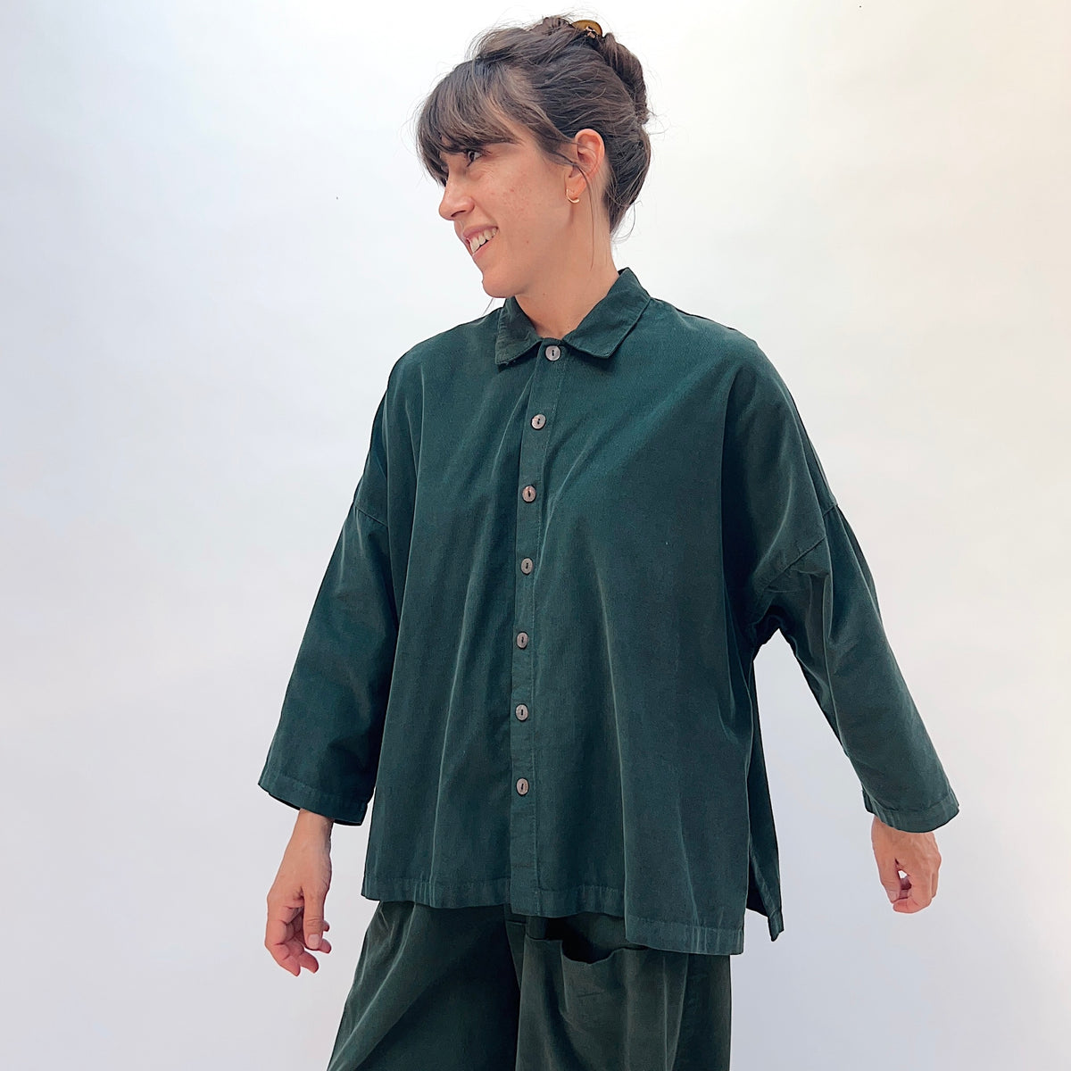 Eleven Stitch Corduroy Big Shirt in Konbu, front three-quarter view showing the classic collar, shell buttons, and oversized silhouette in dark green fine-wale corduroy
