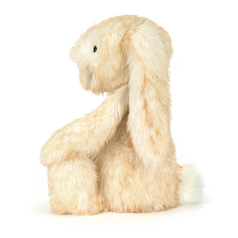 Side view of the Jellycat Springlowe Luxe Bunny showing  a profile of long floppy ears draped down the back and a small white cotton tail, on a white background