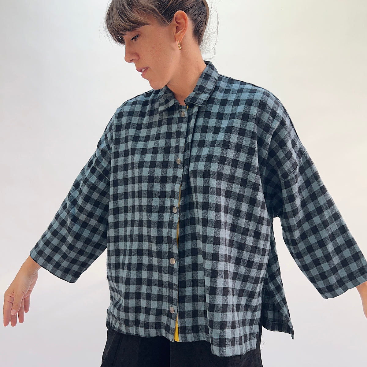 Eleven Stitch Big Check Big Shirt in Dusty Denim, angled front view showing the relaxed boxy fit and mustard contrast placket in dusty blue and black gingham check flannel
