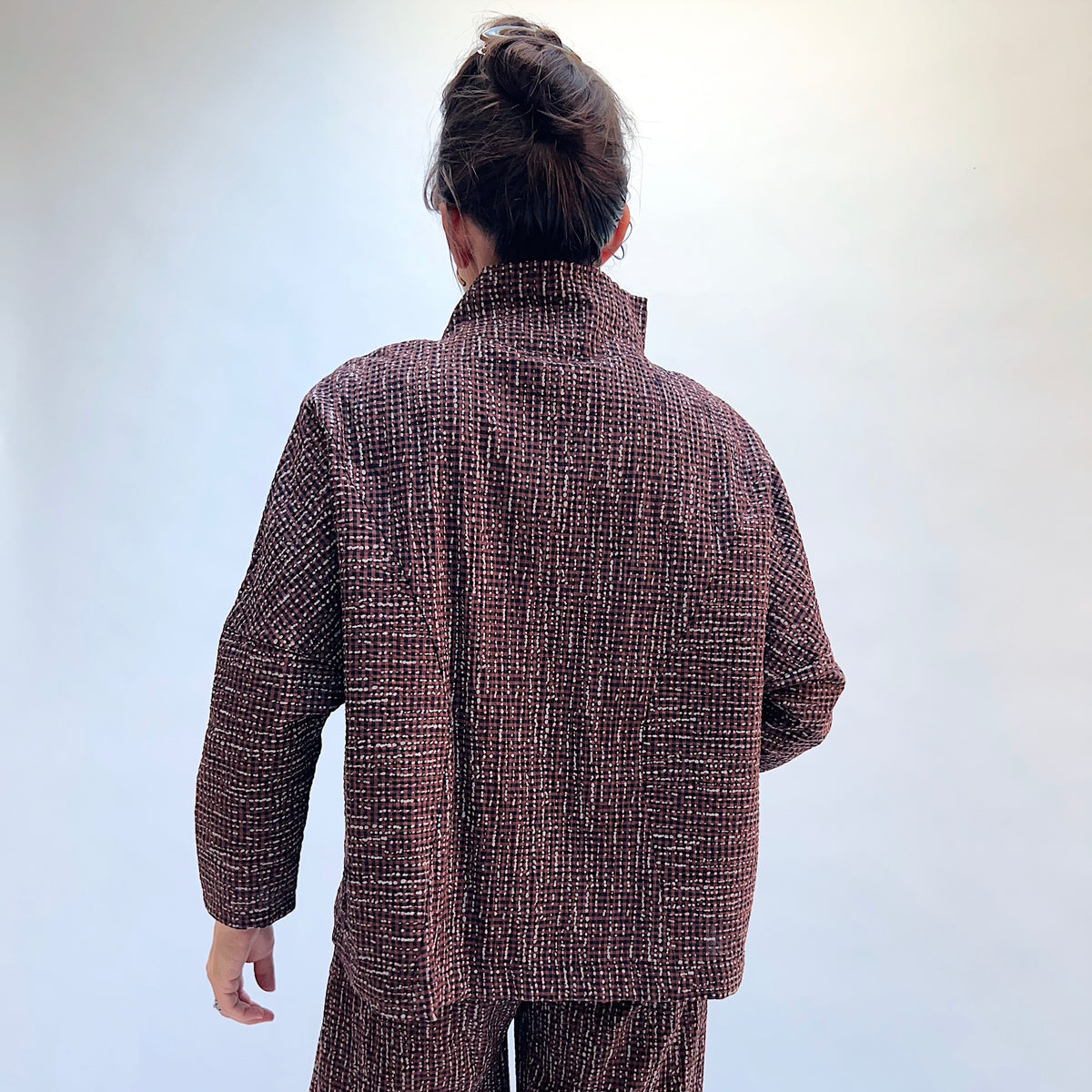 Niche Sofi Top in Cocoa Check, back view showing the relaxed boxy silhouette and high funnel neck in dark brown textured check
