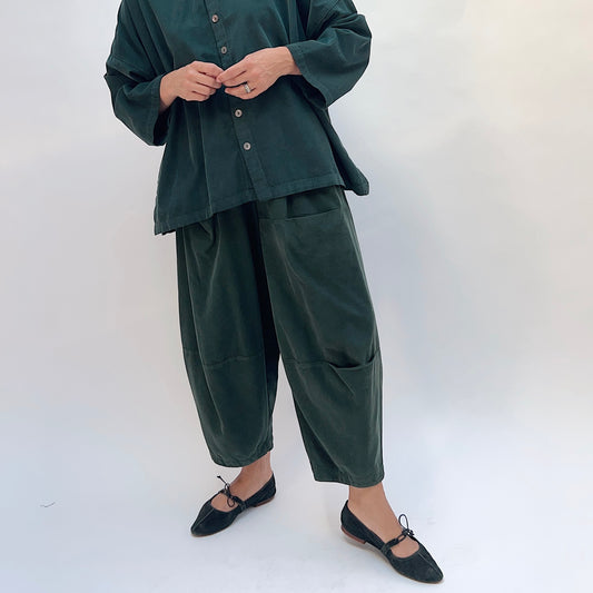 Eleven Stitch Corduroy Three Pocket Pant in Konbu, front view showing the wide-leg barrel silhouette and patch pockets in dark green fine-wale corduroy
